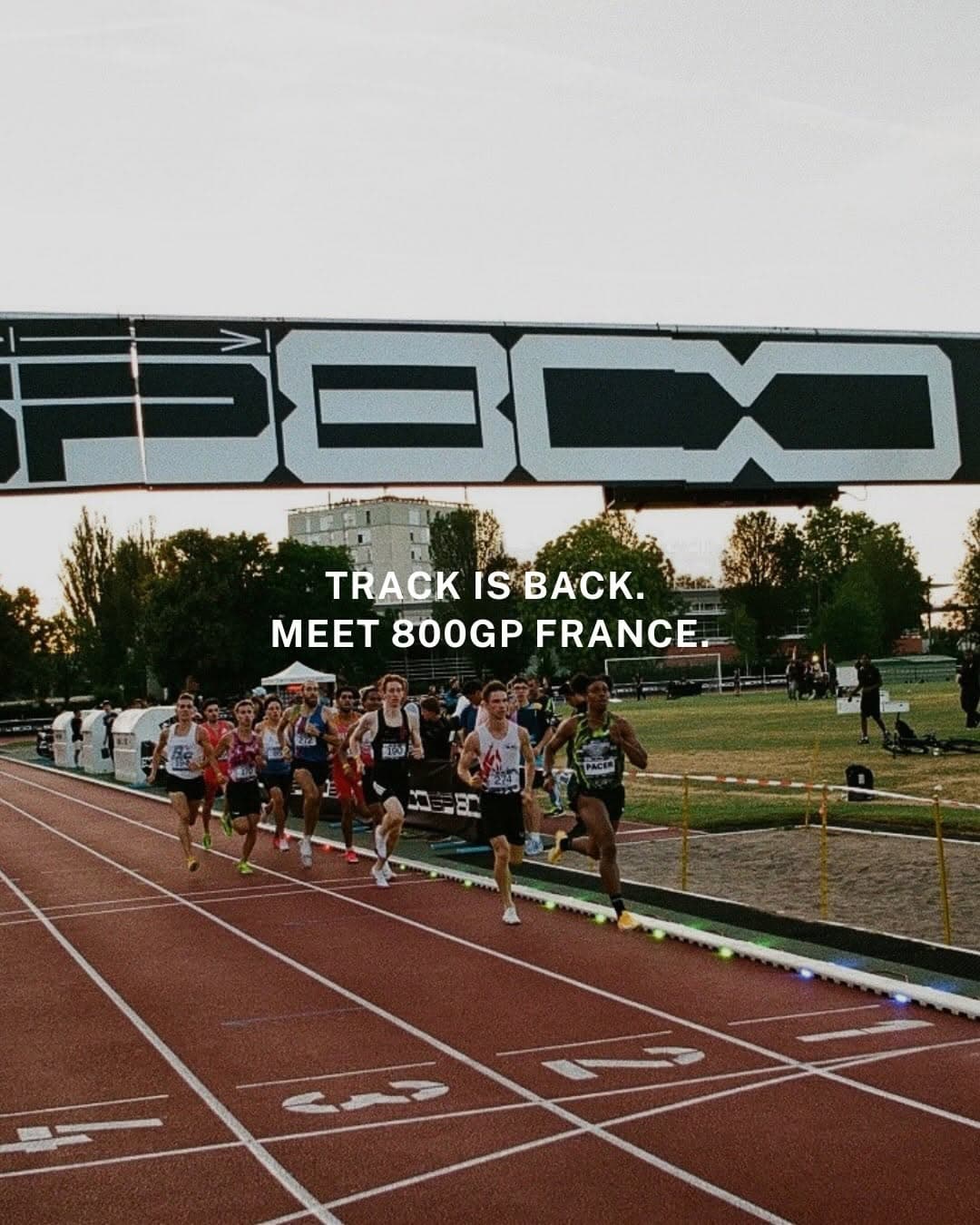 Elite middle-distance runners competing on an outdoor track at the 800GP meet in Aulnay-sous-Bois with spectators lining the sidelines at dusk