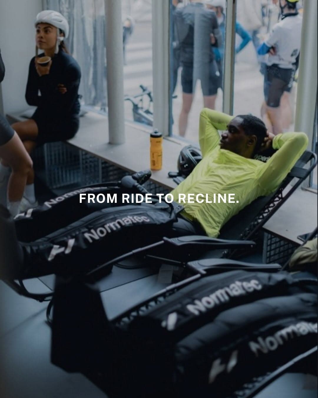 Cyclists relaxing in recovery boots together at a cycling studio after a group ride